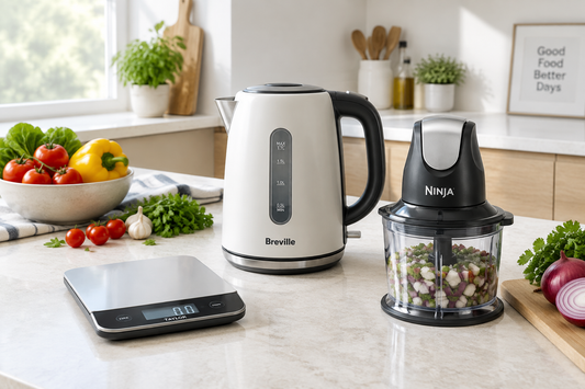 A digital scale, electric kettle, and small chopper on a bright kitchen counter